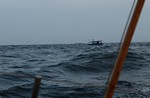 een vissersboot op zee ten anker met 5 enthausiaste zwaaiers