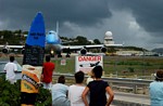 Boeing klaar om te vertrekken, vertrektijden staan op de surfplank. Let ook op het waarschuwingsbord!